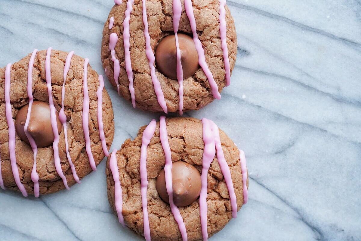 3 Double Chocolate Cherry Kiss Thumbprint cookies sitting on a marble counter