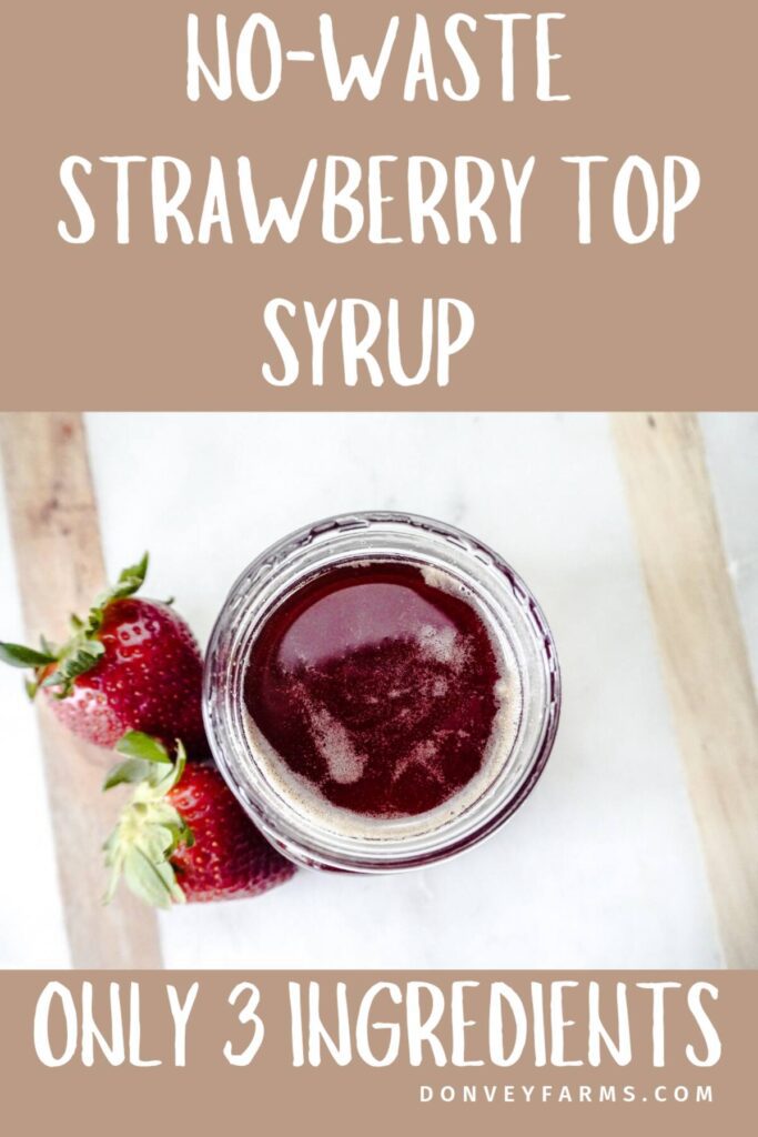 top view looking into jar of strawberry top simple syrup on marble counter with 2 fresh strawberries next to the 1/2 pint jar. 