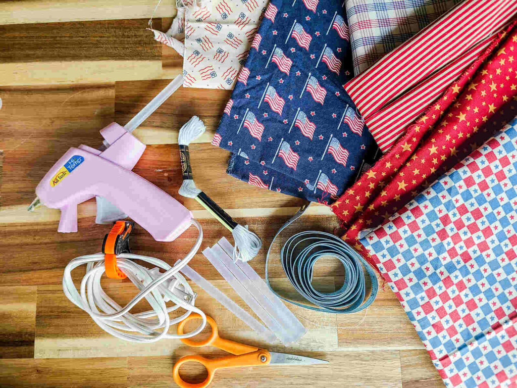 materials needed for this project: glue gun, glue sticks, measuring tape, string, scissors and fabric 