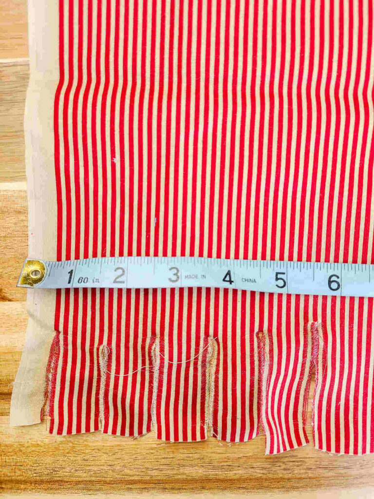 measuring tape set to cut strips of fabric for banner