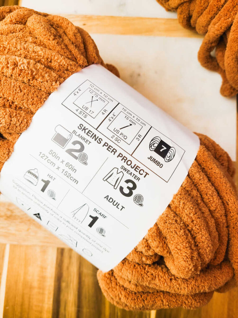 close up of plush orange skein of yarn stating its a jumbo number 7 weight 