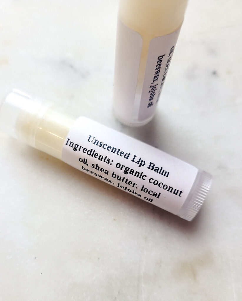 unscented lip balm tube laying flat on a marble counter top. 