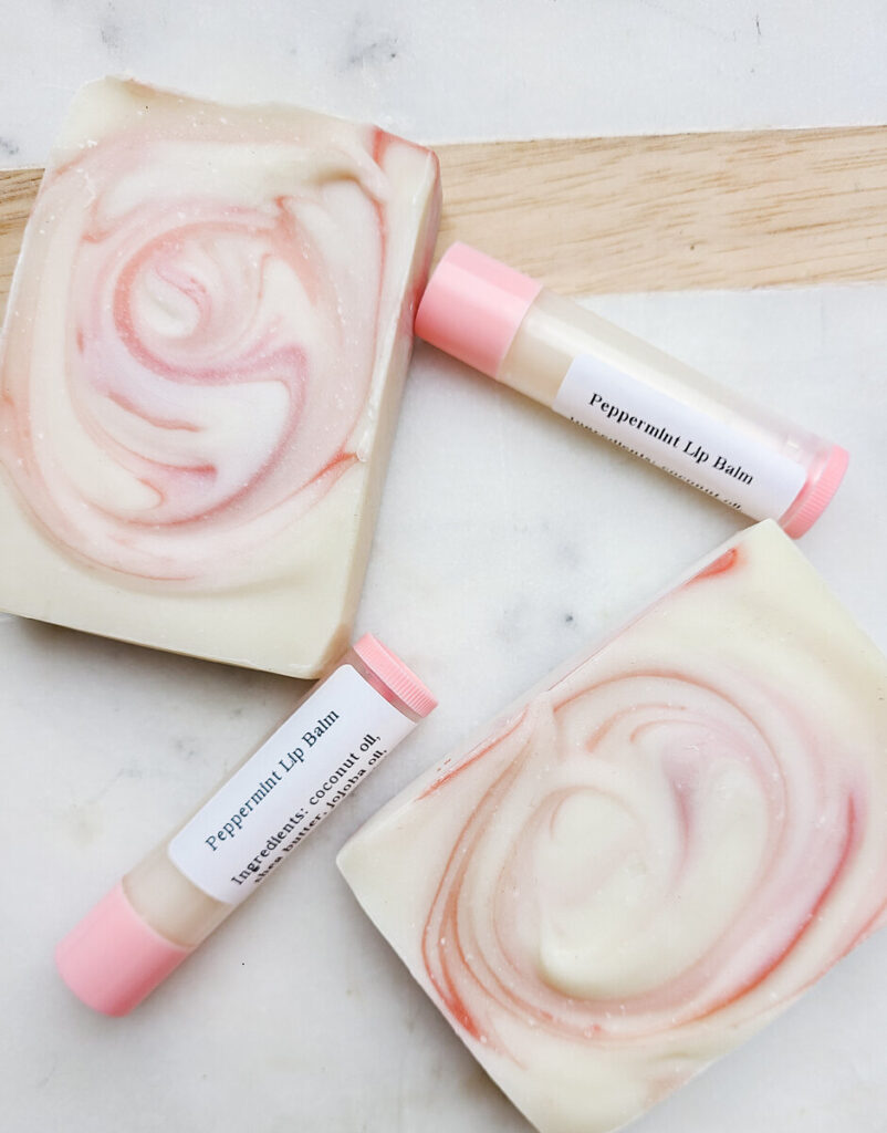 peppermint lip balm tubes on counter top next to peppermint swirl soap bars