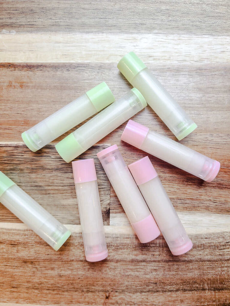 filled lip balm tubes laying flat on wood counter top.