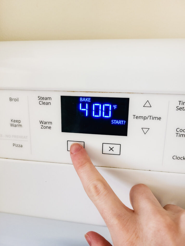 woman preheating oven to 400 degrees