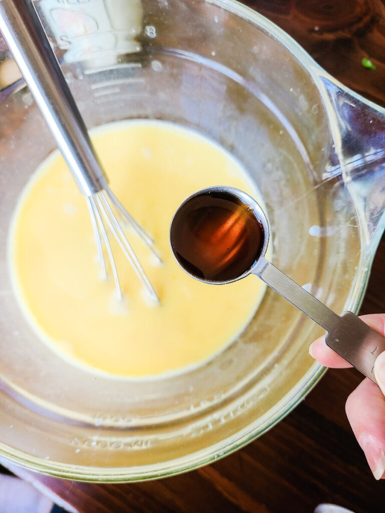 woman mixing wet ingredients together in liquid measuring cup 