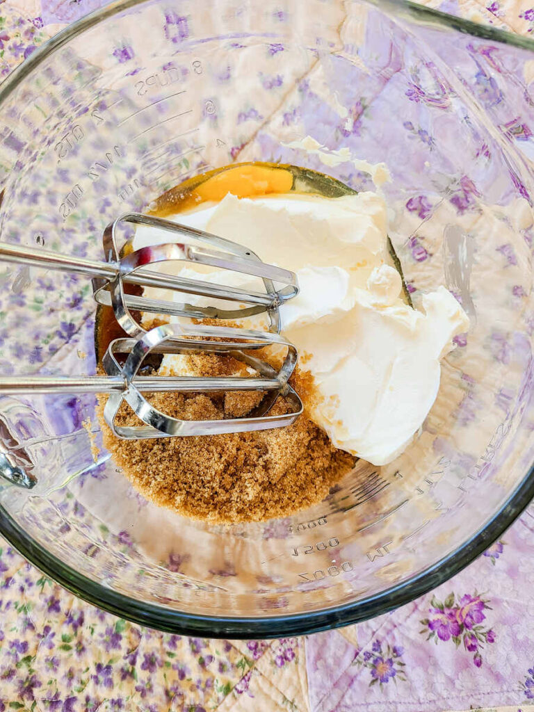 eggs, cream cheese, sugar, combined in liquid glass measuring cup for cream cheese filling of bars 