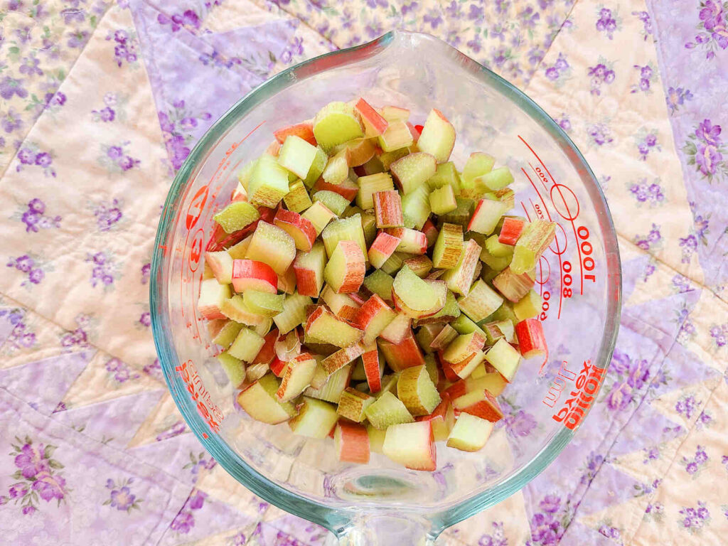 large glass liquid measuring bowl full of fresh chopped rhubarb
