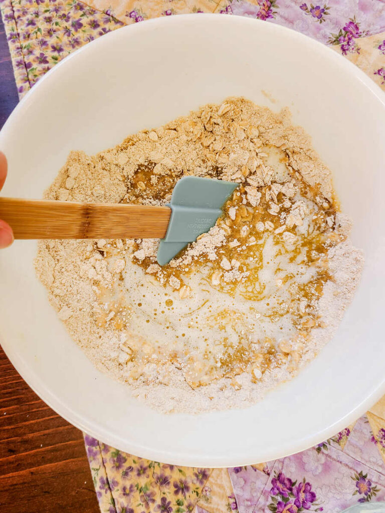 woman mixing dry ingredients into crust for bars