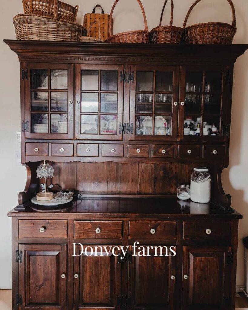 Ethan Allen Old Tavern Pine collection hutch with dark wood, the exposed hinges, glass panes, and contrast porcelain drawer knobs. 