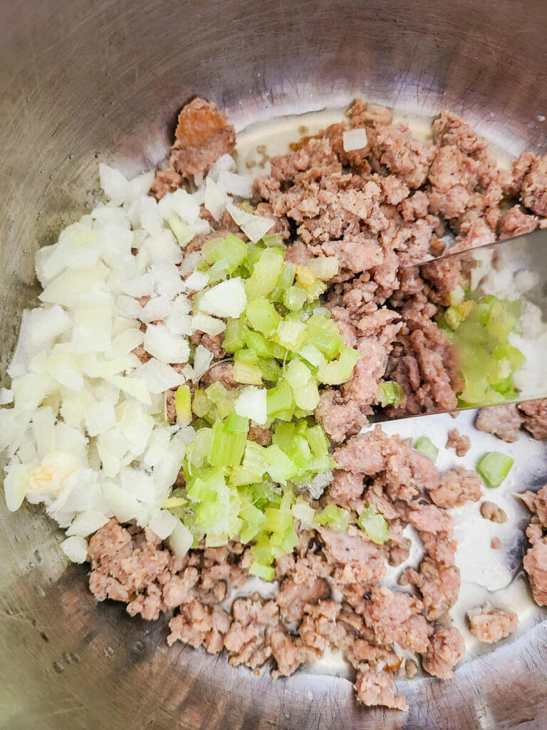 instant pot with celery, onions, and ground pork sausage