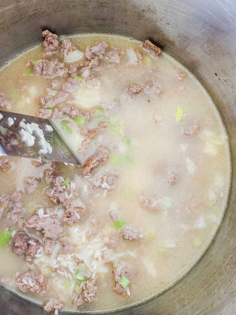 woman adding rice to instant pot to cook in broth mixture