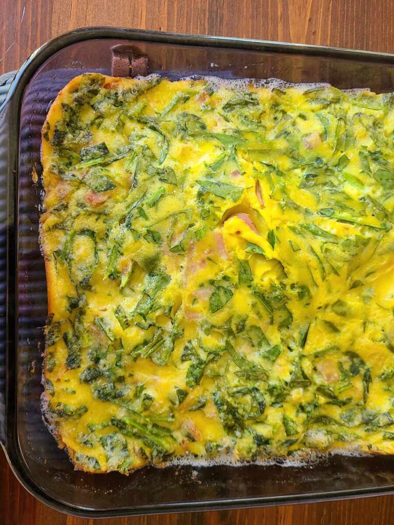 cooked pan of savory German pancake with ham and spinach 