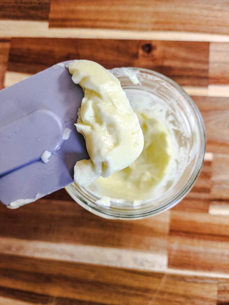 spatula dipped in egg white mayo above jar of mayo 
