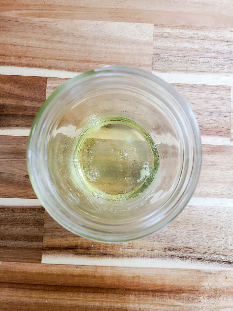 woman adding egg white to jar 