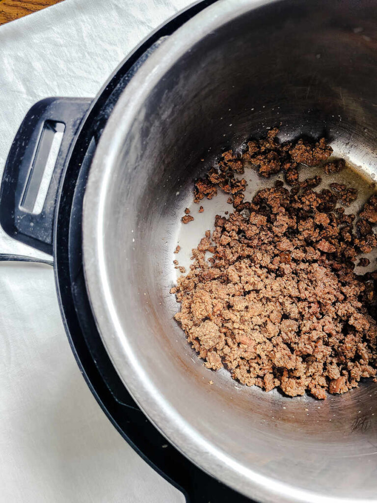 woman sautéing ground beef in instant pot 