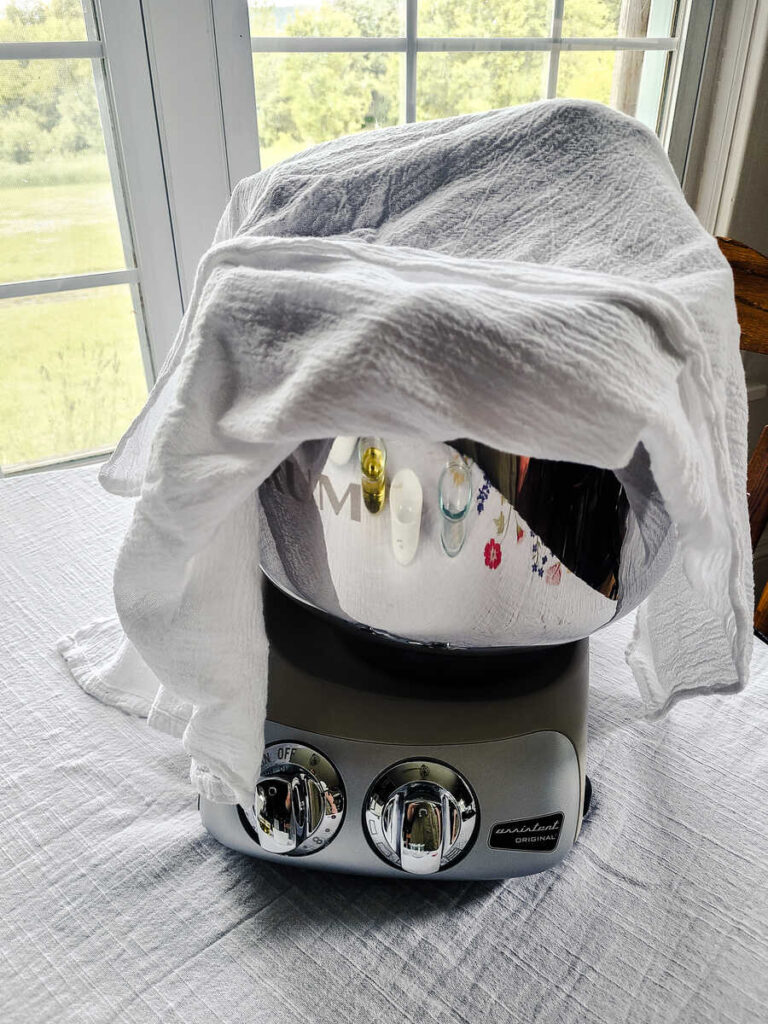 ankarsrum mixer covered with towel letting dough mixture rise under it 