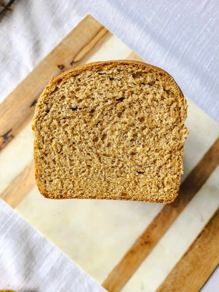 sliced of whole wheat sandwich bread on wood and marble cutting board 