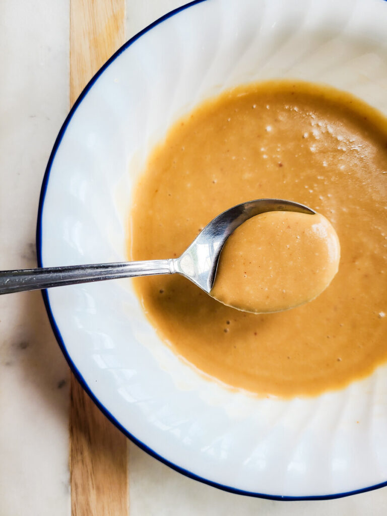 bowl with kimchi mayo sauce with spoon dipped into it